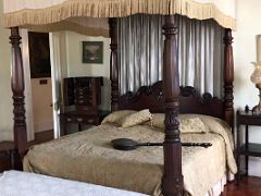 09A The master bedroom has a wooden framed canopy bed with a bed warmer Devon House mansion Kingston Jamaica